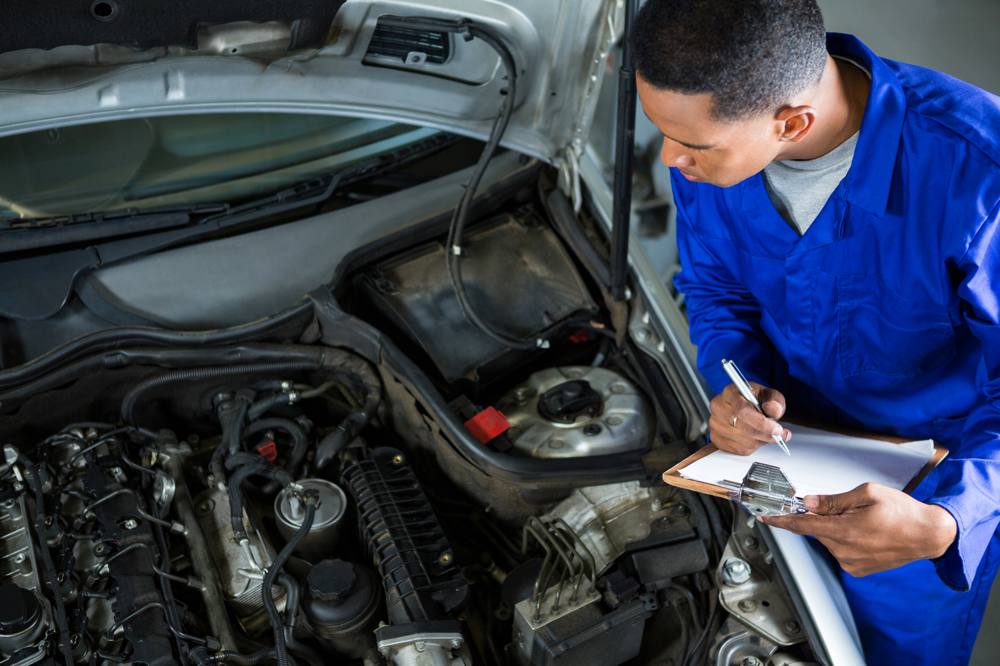 Vor-Ort-Prüfung mit Checkliste am geöffneten Motorraum